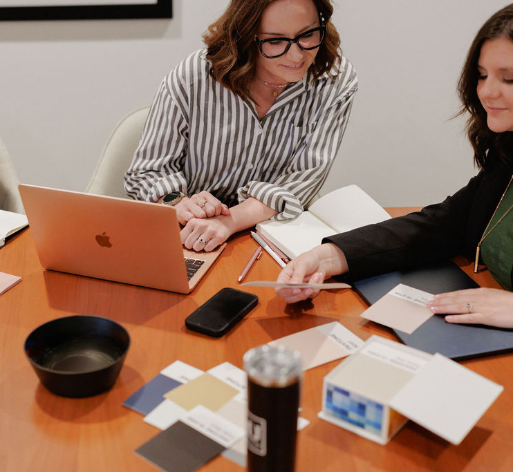 Two website support team members reviewing a website at conference room table